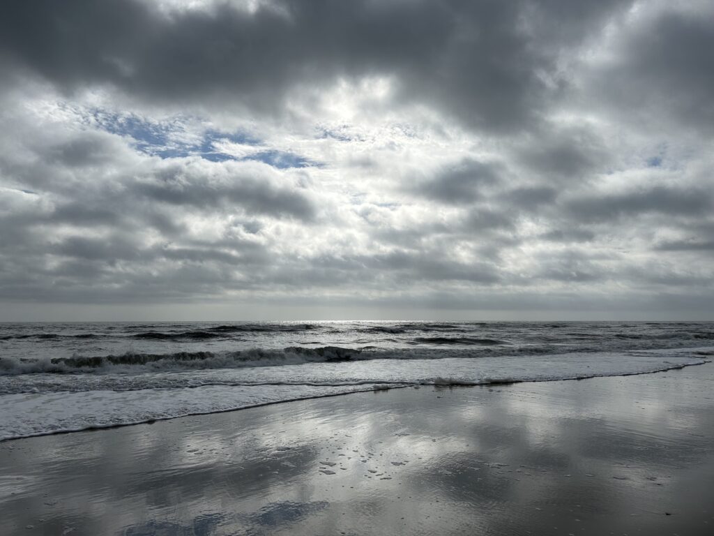 looking out over ocean. Dark cloudy day with sun peeking through